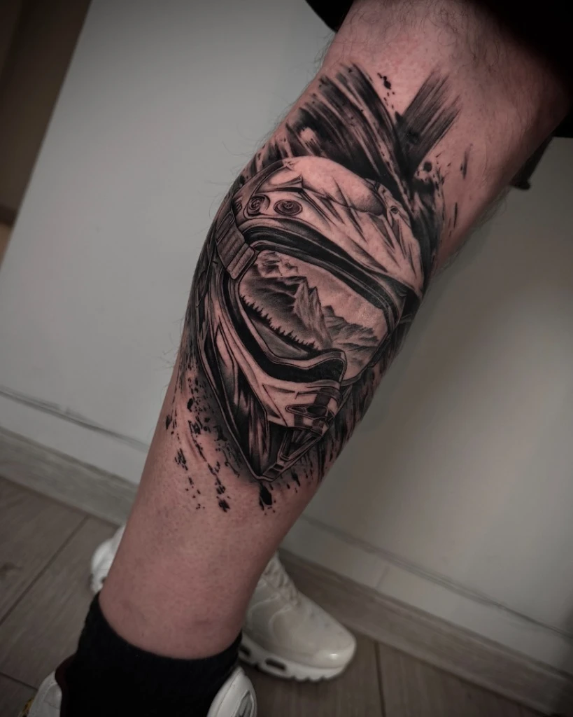 Tatuaj realism cu cască motocross și reflexie de munți
