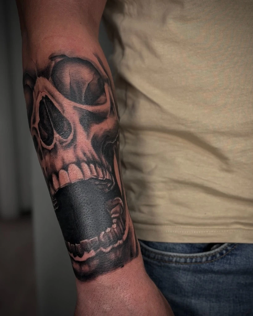 Tatuaj dark realism cu craniu pe antebraț