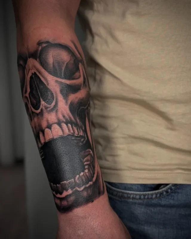 Tatuaj dark realism cu craniu pe antebraț